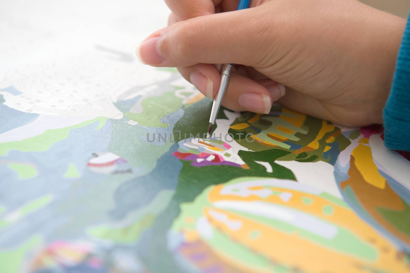 3 - Selective focus on brush tip, painting by numbers. A common Covid lock down quarantine hobby. Close up image with detail and vivid color.