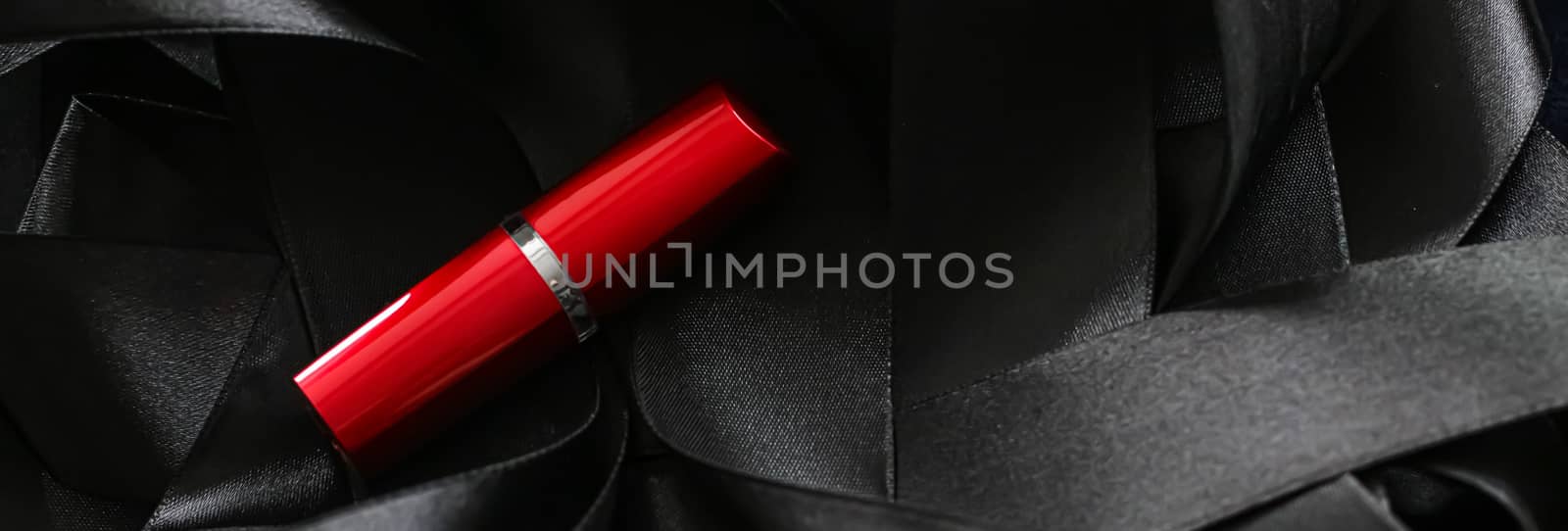 Red lipstick on black silk background, luxury make-up and beauty cosmetics