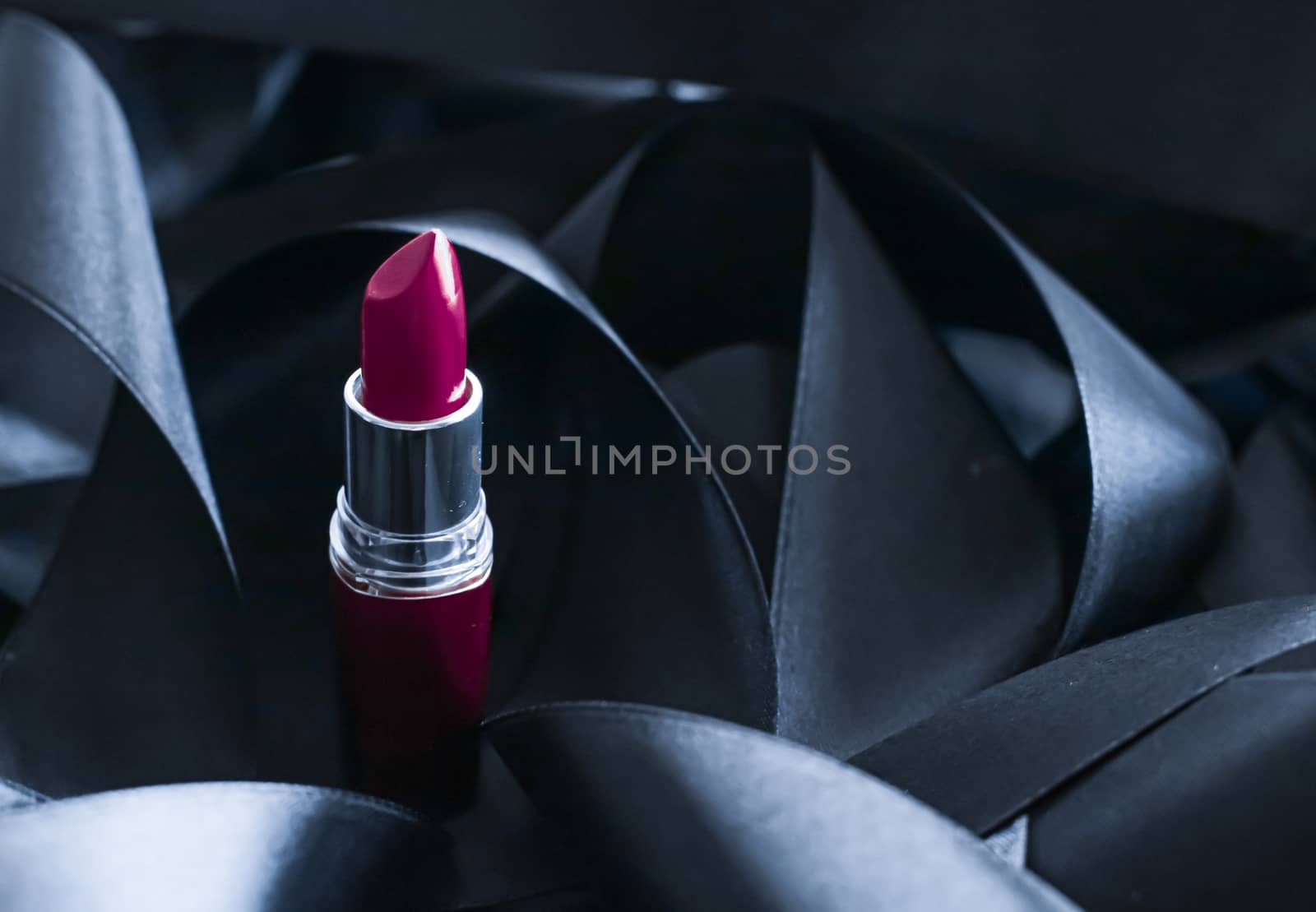 Purple lipstick on black silk background, luxury make-up and beauty cosmetics