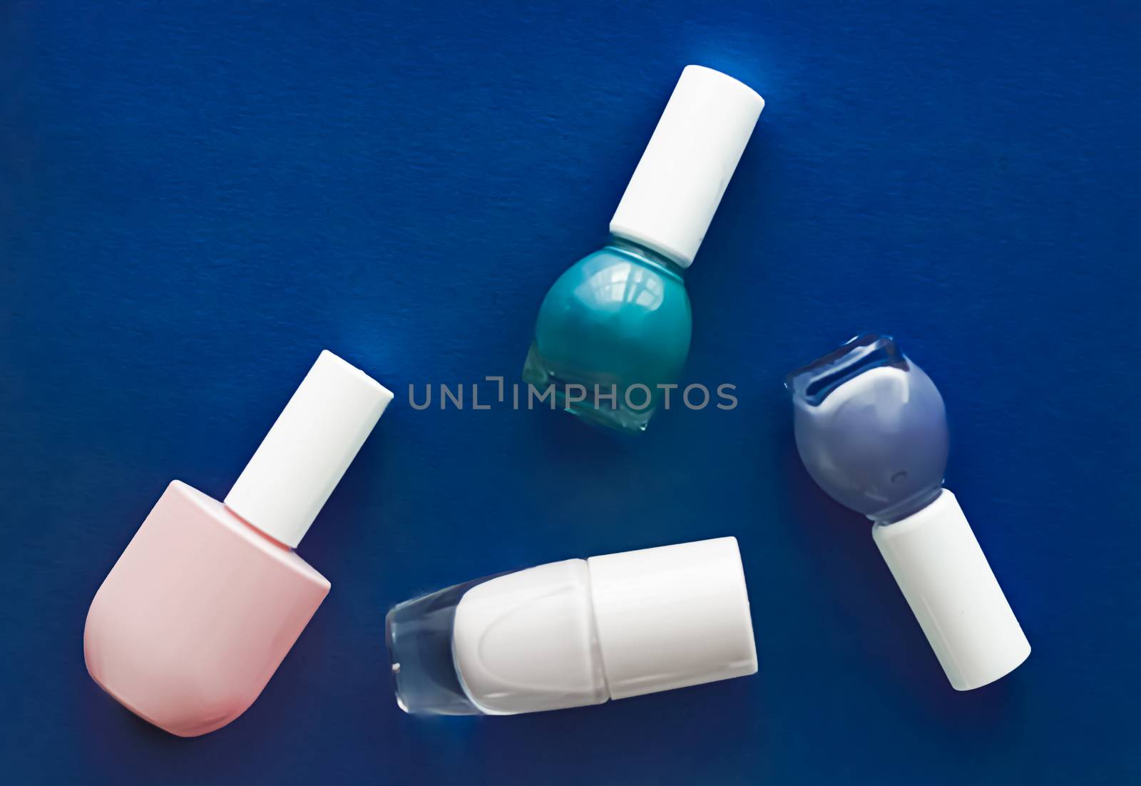 Nail polish bottles on dark blue background, beauty brand by Anneleven