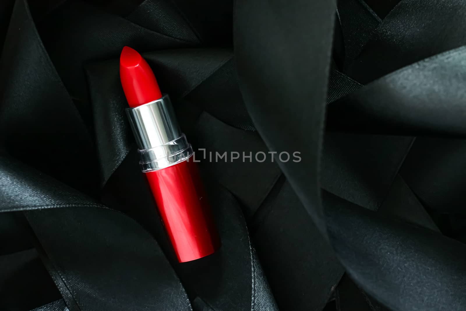 Red lipstick on black silk background, luxury make-up and beauty cosmetics