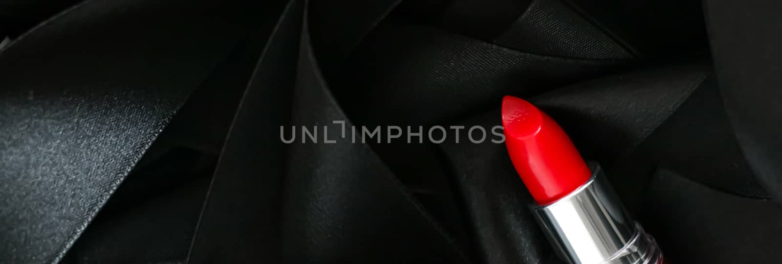 Red lipstick on black silk background, luxury make-up and beauty cosmetics