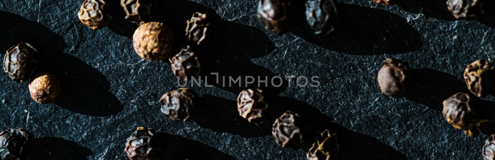 Black pepper closeup on luxury stone background as flat lay, dry food spices and recipe ingredients