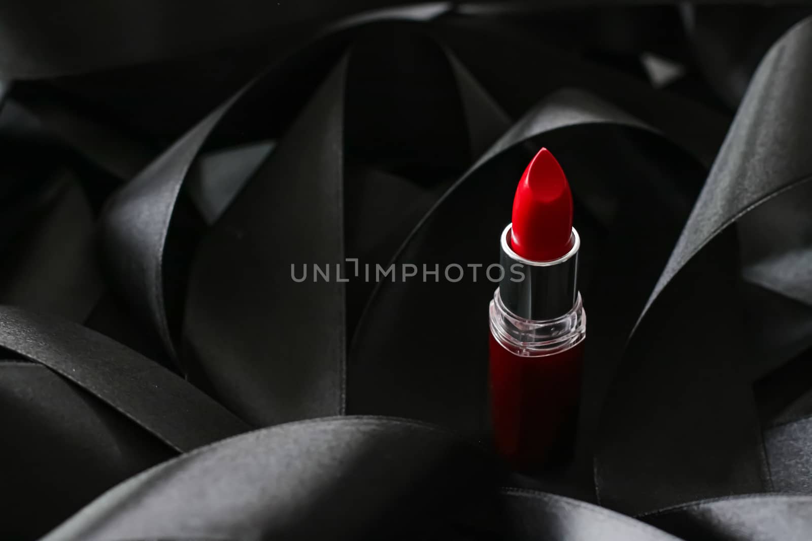 Red lipstick on black silk background, luxury make-up and beauty cosmetics