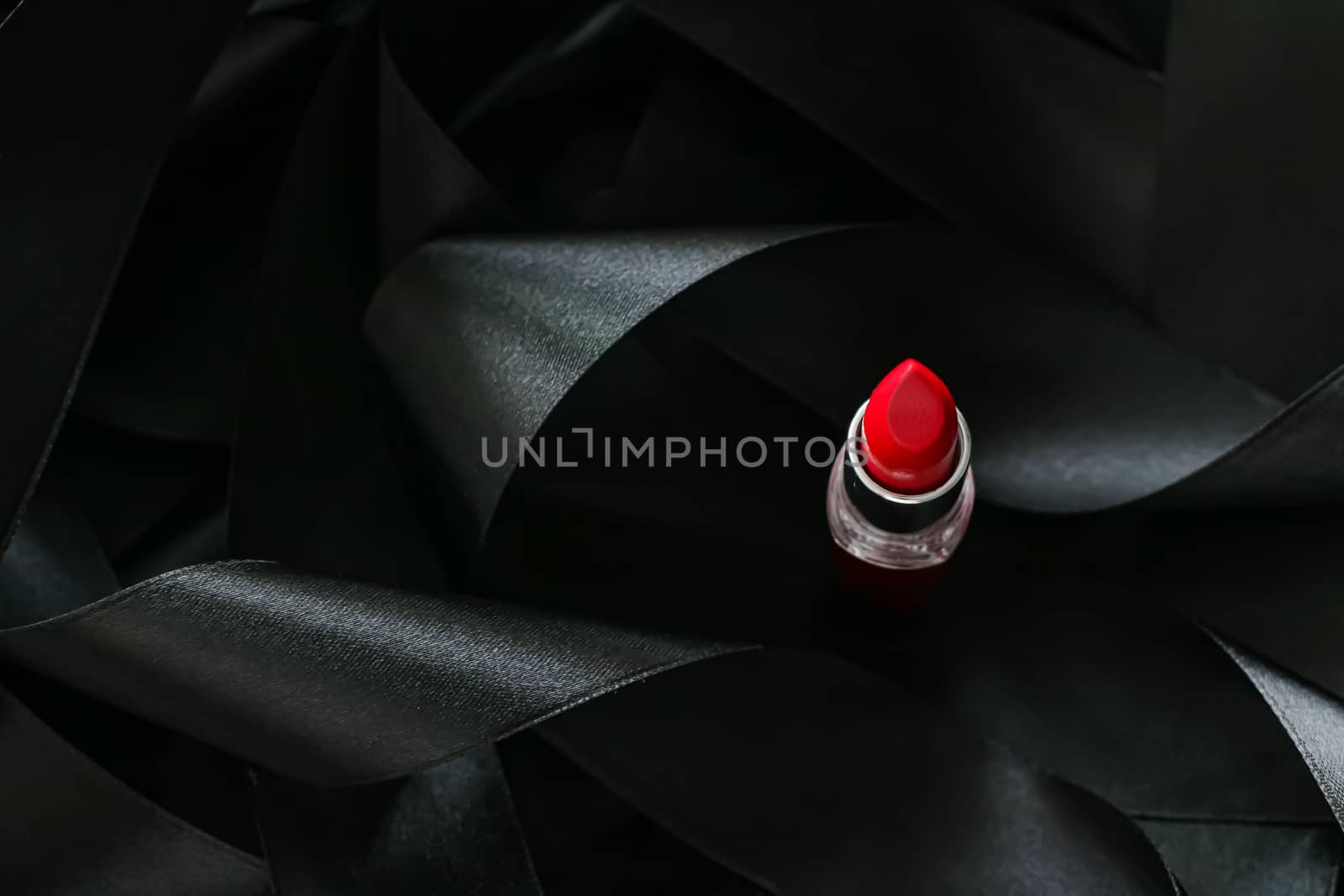 Red lipstick on black silk background, luxury make-up and beauty cosmetics