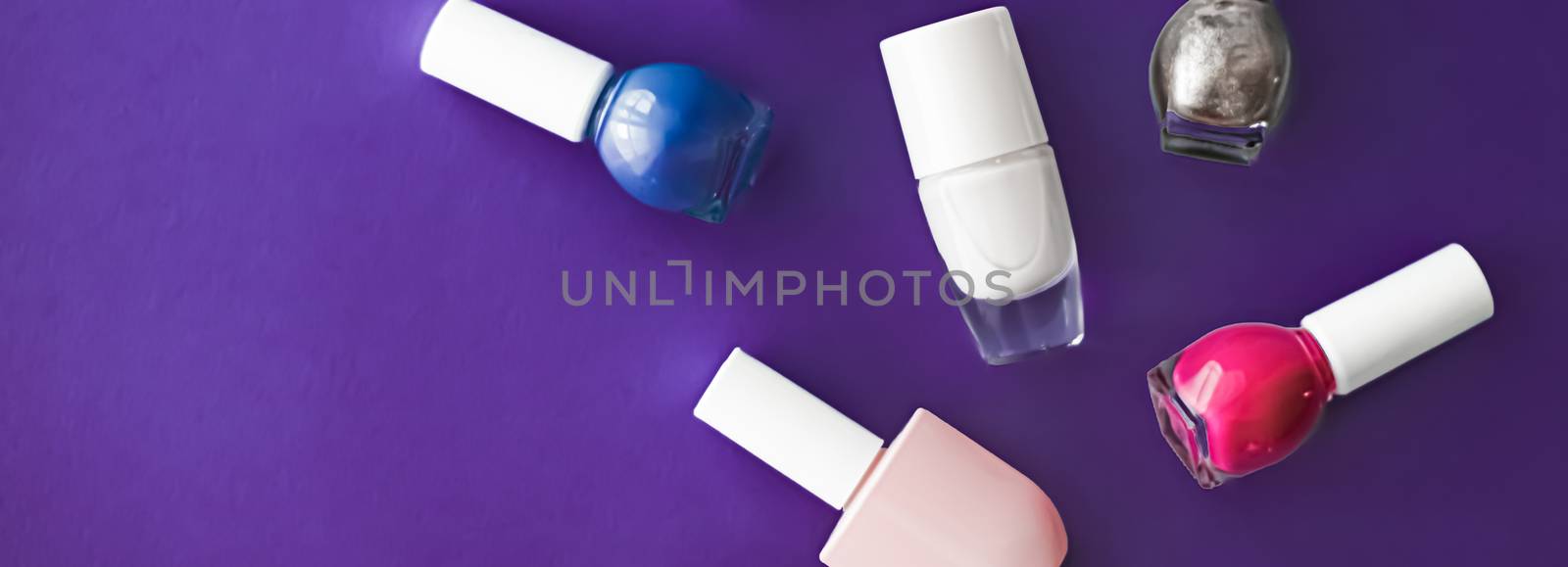 Nail polish bottles on dark purple background, beauty brand by Anneleven