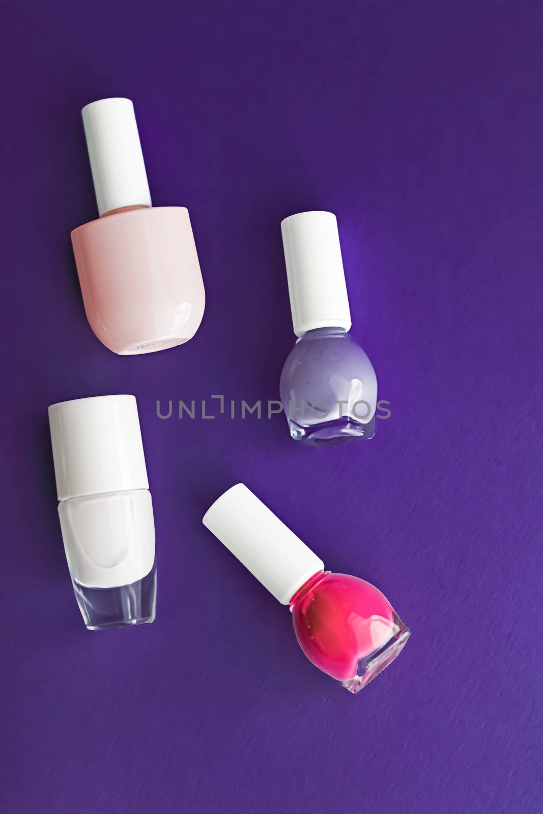 Nail polish bottles on dark purple background, beauty brand by Anneleven