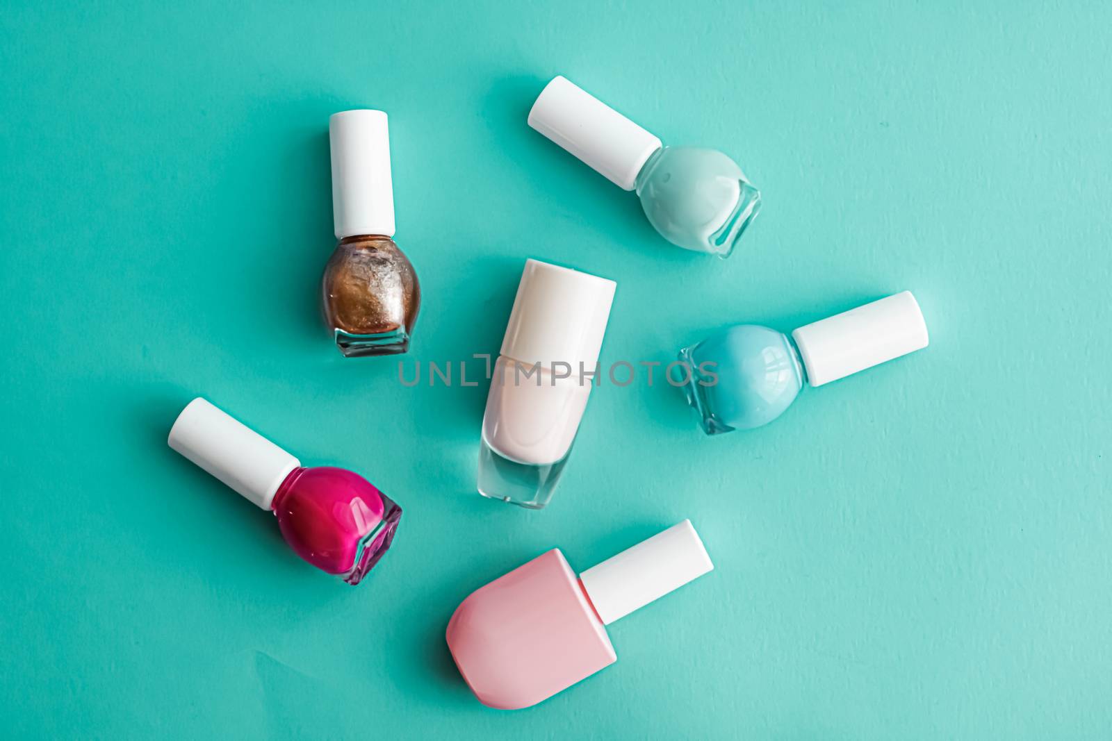 Nail polish bottles on green background, beauty branding