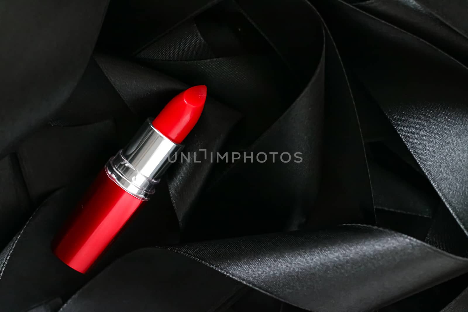 Red lipstick on black silk background, luxury make-up and beauty cosmetics