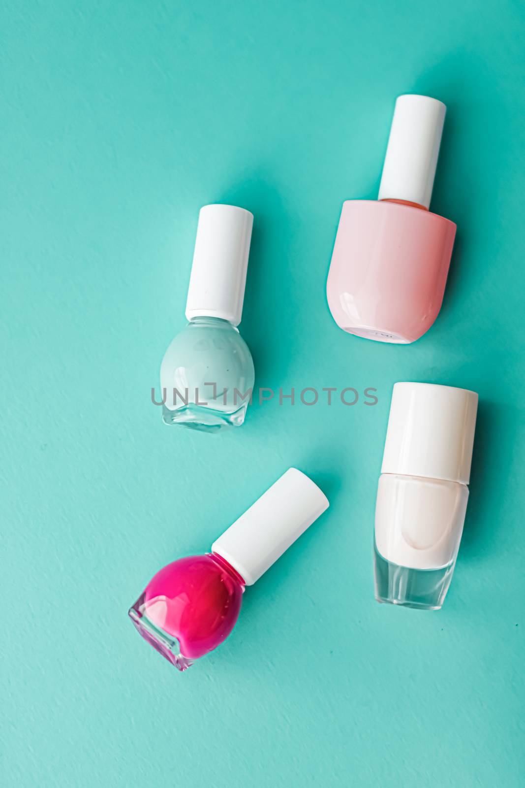 Nail polish bottles on green background, beauty branding