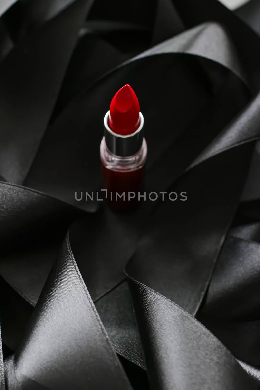 Red lipstick on black silk background, luxury make-up and beauty by Anneleven