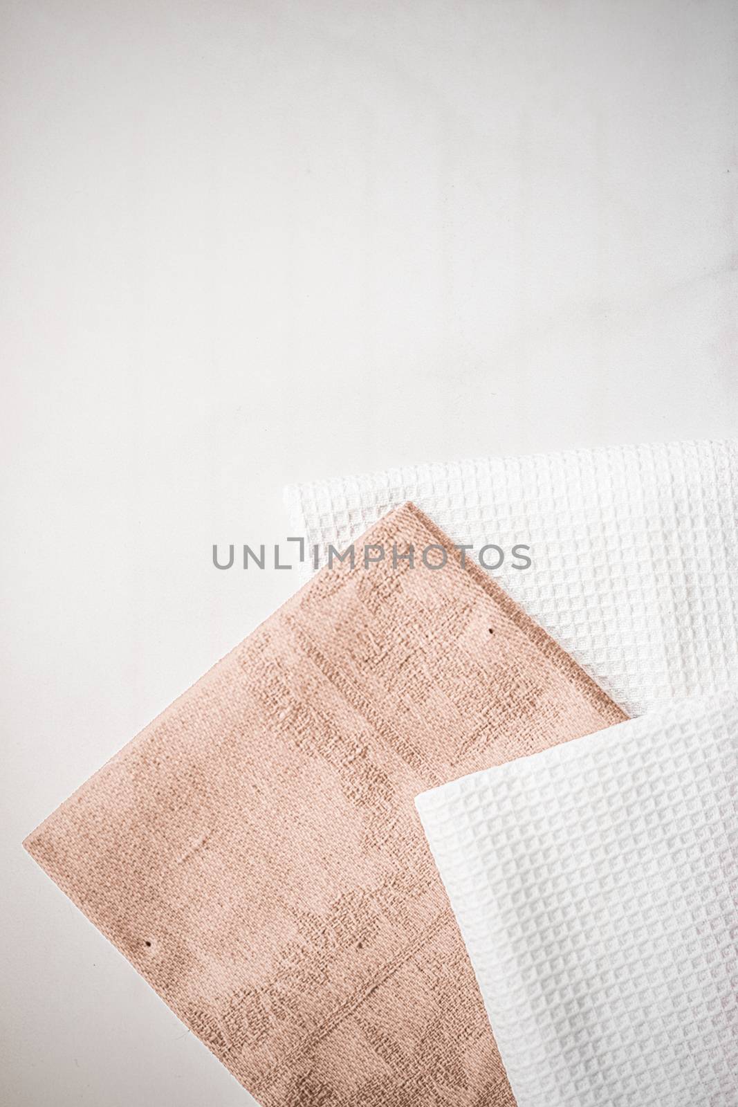 Tableware, material or cloth concept - Kitchen textile on chic white marble background, napkin and towel set, folded fabrics as food styling props for luxury home decor brand, interior design