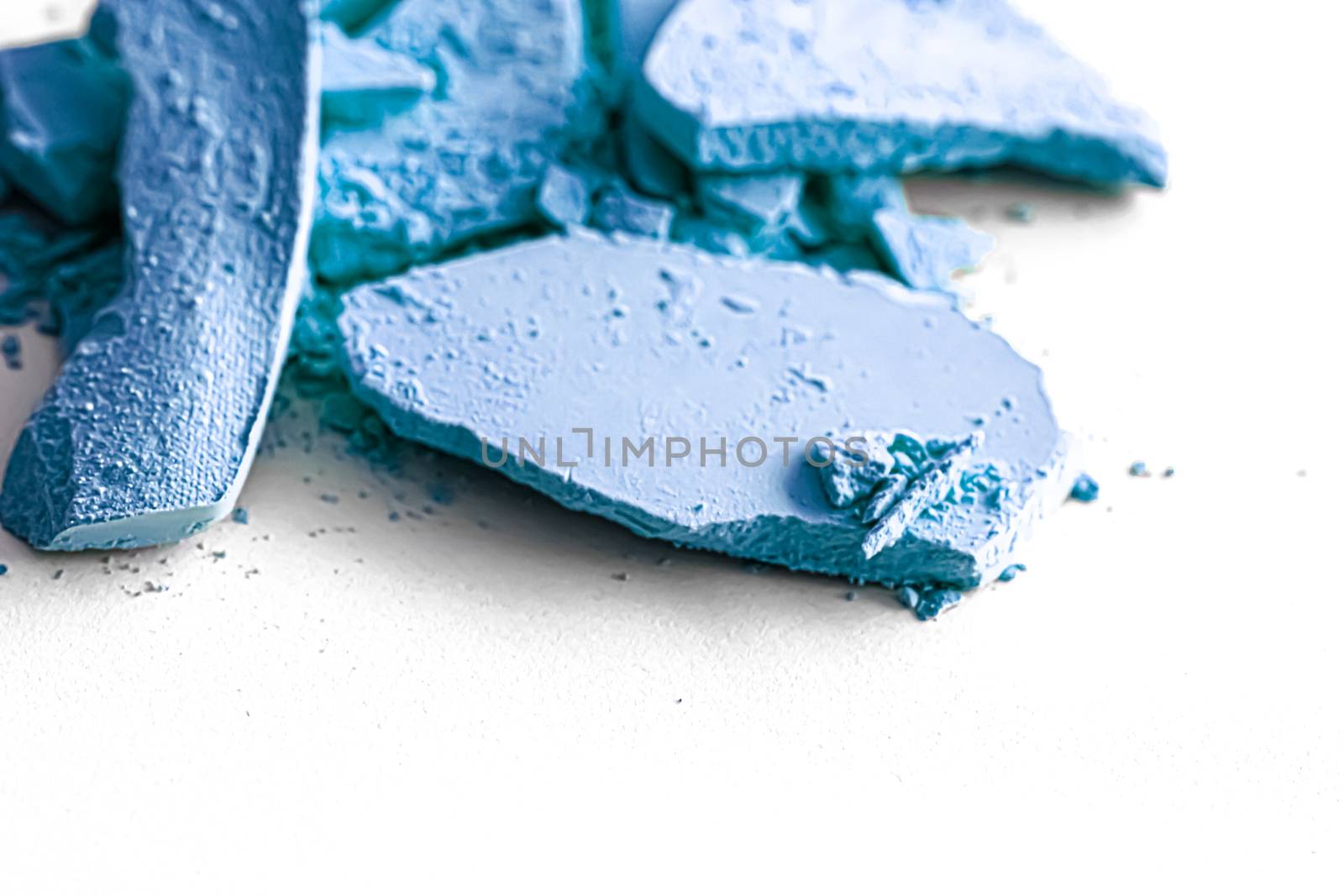 Blue eye shadow powder as makeup palette closeup isolated on white background, crushed cosmetics and beauty textures
