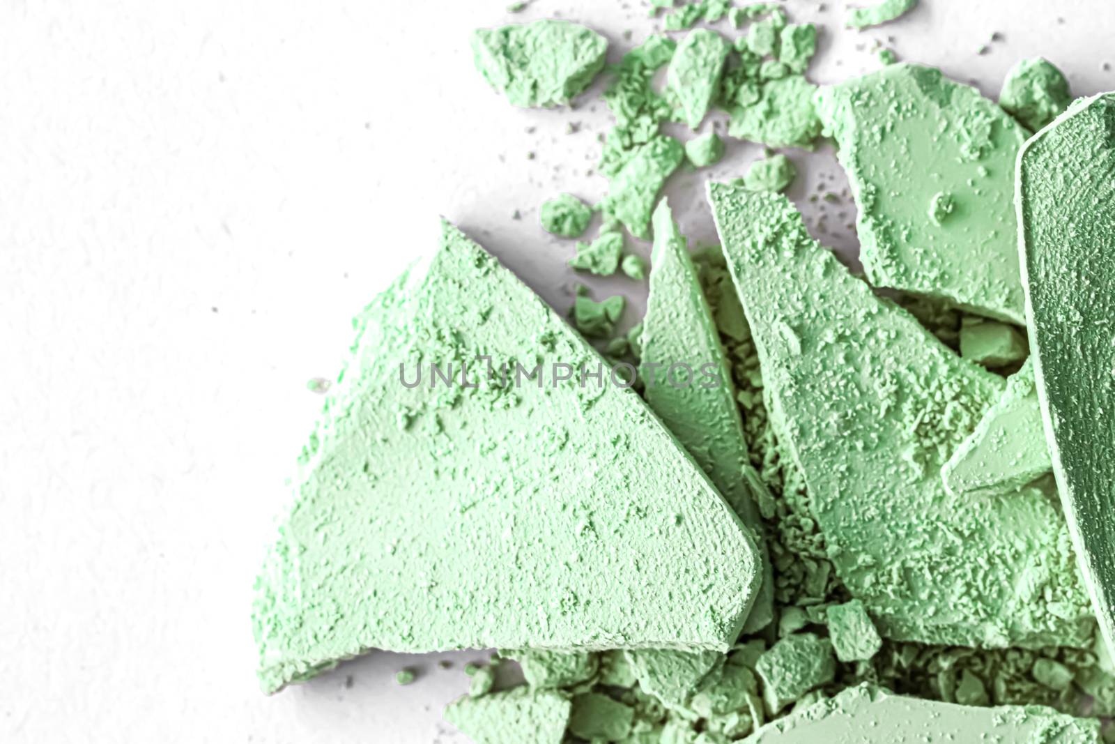 Green eye shadow powder as makeup palette closeup isolated on white background, crushed cosmetics and beauty textures