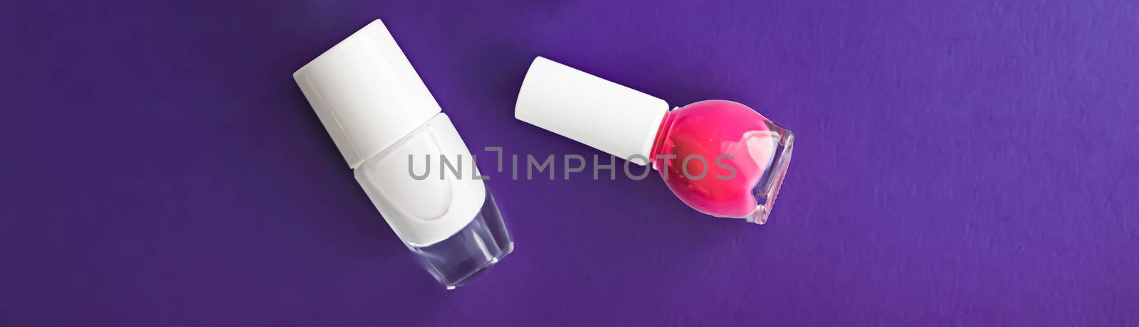 Nail polish bottles on dark purple background, beauty branding