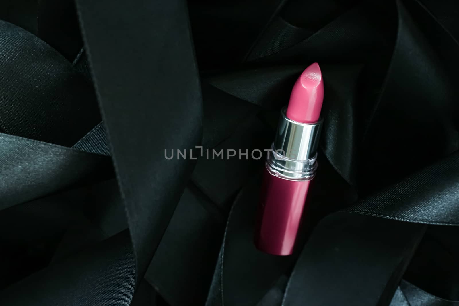 Pink lipstick on black silk background, luxury make-up and beauty cosmetics