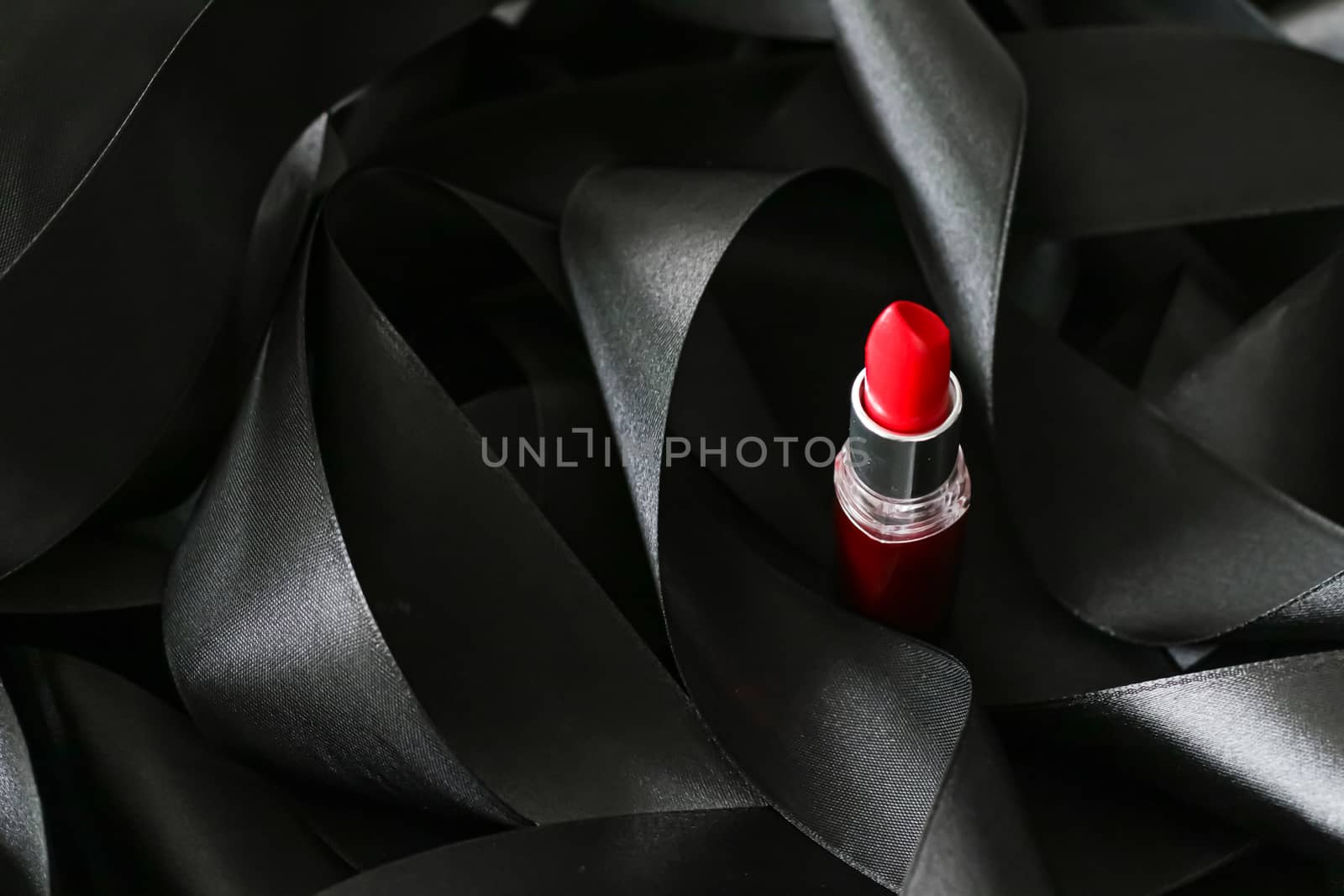 Red lipstick on black silk background, luxury make-up and beauty cosmetics