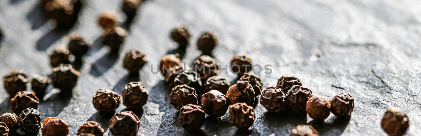 Black pepper closeup on luxury stone background as flat lay, dry food spices and recipe ingredients