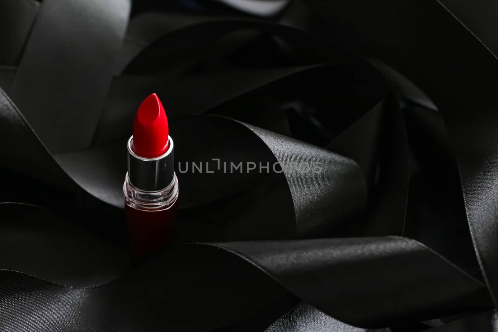 Red lipstick on black silk background, luxury make-up and beauty by Anneleven