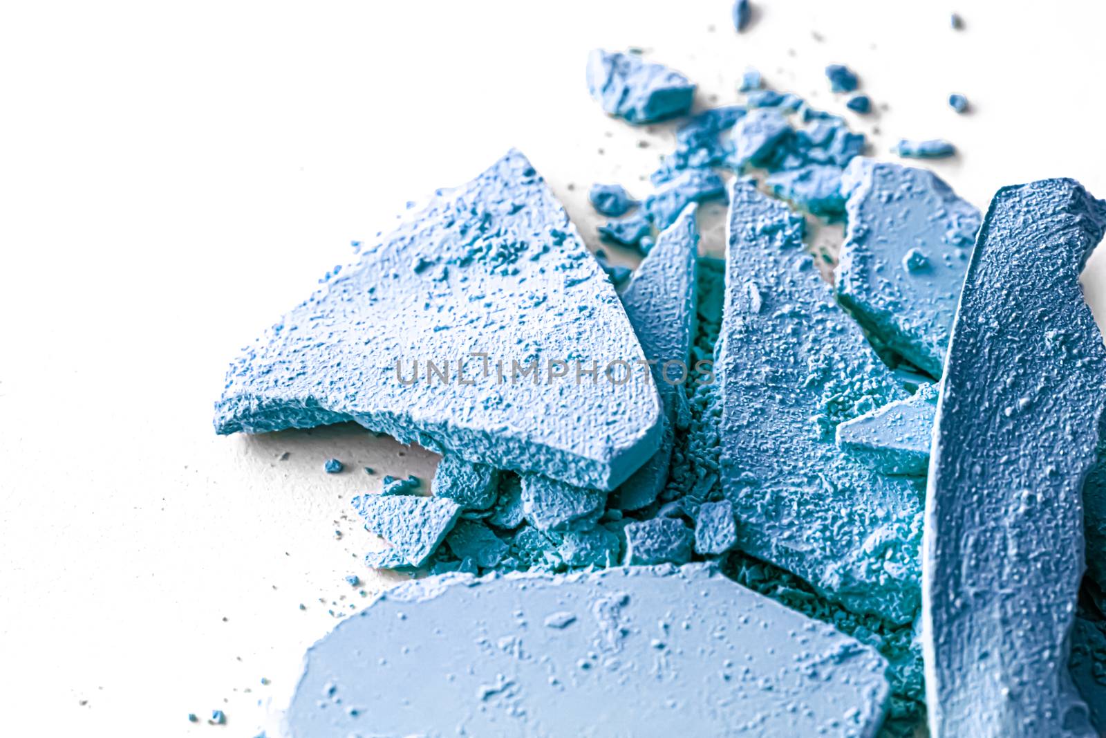 Blue eye shadow powder as makeup palette closeup isolated on white background, crushed cosmetics and beauty textures