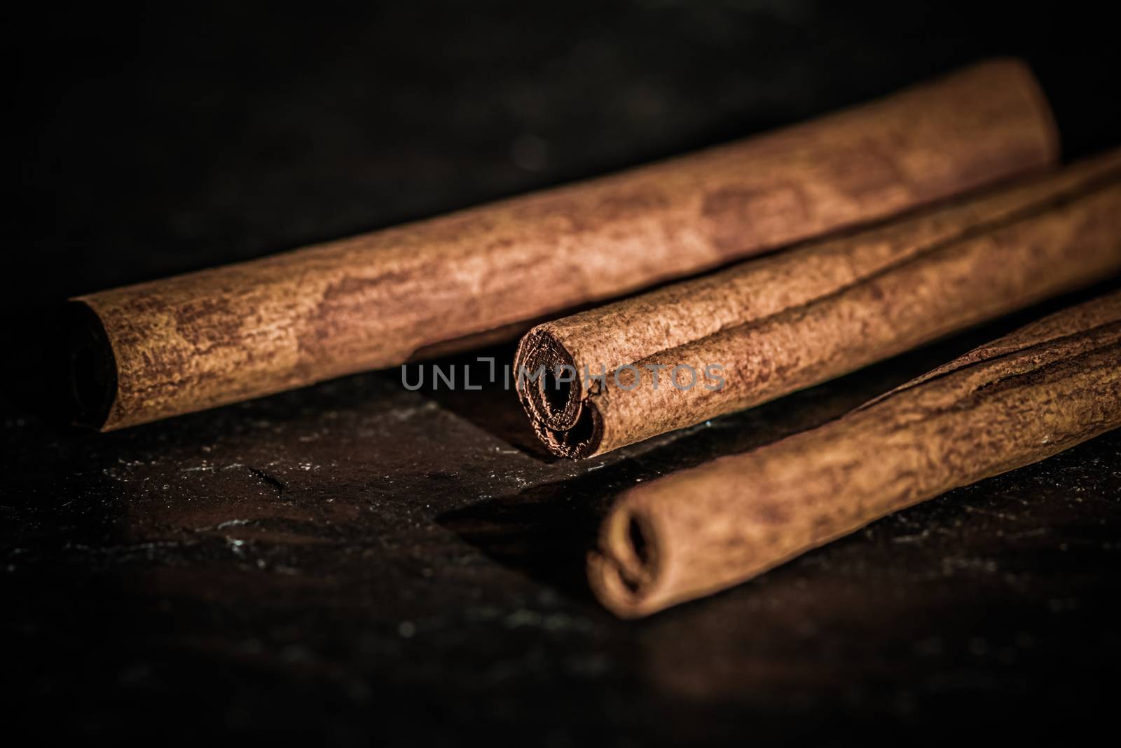 Cinnamon sticks on black stone background, food recipes