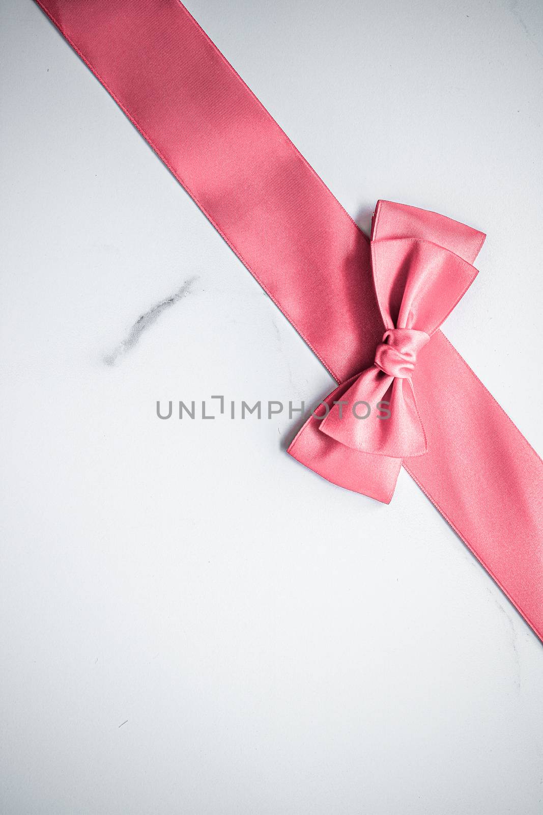 Birthday, wedding and girly branding concept - Coral silk ribbon and bow on marble background, girl baby shower present and glamour fashion gift decor for luxury beauty brand, holiday flatlay design