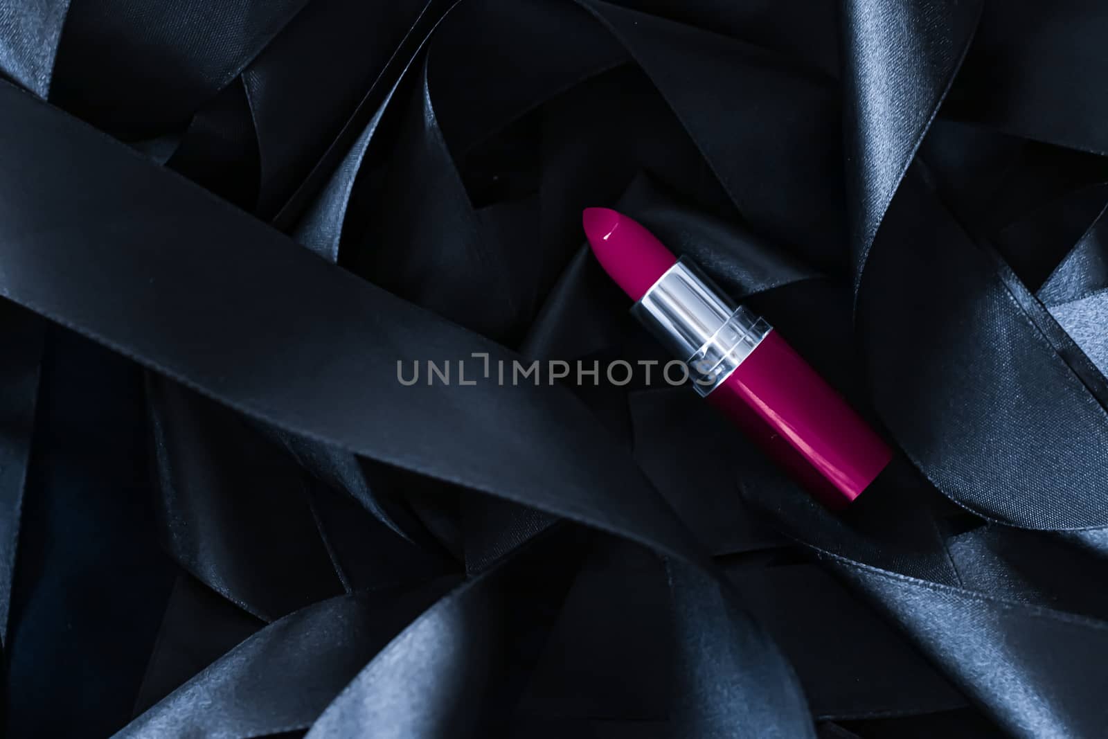 Purple lipstick on black silk background, luxury make-up and beauty cosmetics