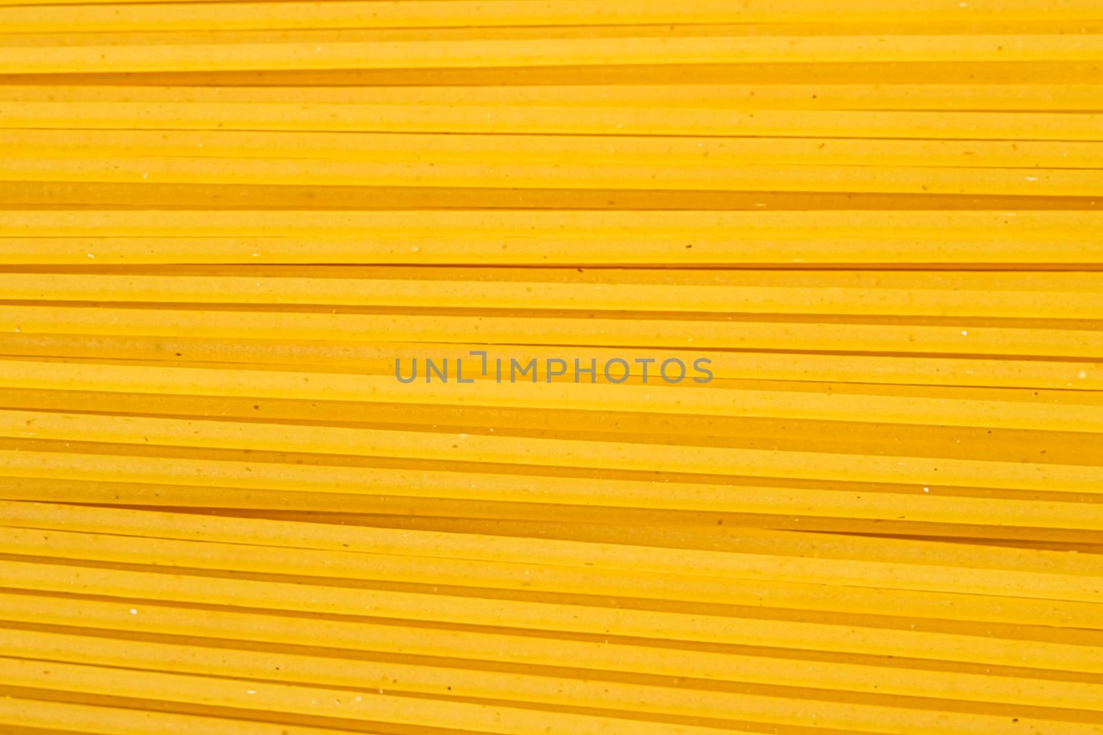 Uncooked whole grain spaghetti closeup, italian pasta as organic food ingredient, macro product and cook book recipes