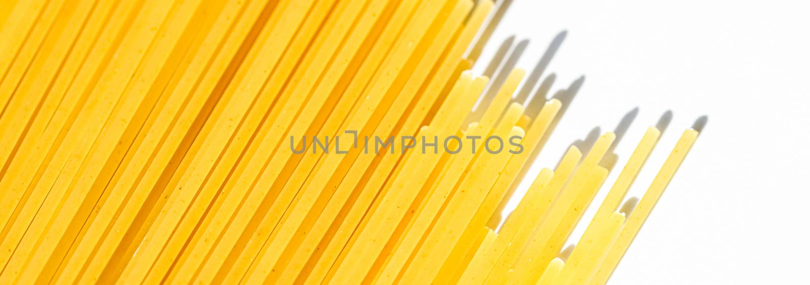 Uncooked whole grain spaghetti closeup, italian pasta as organic food ingredient, macro product and cook book recipes