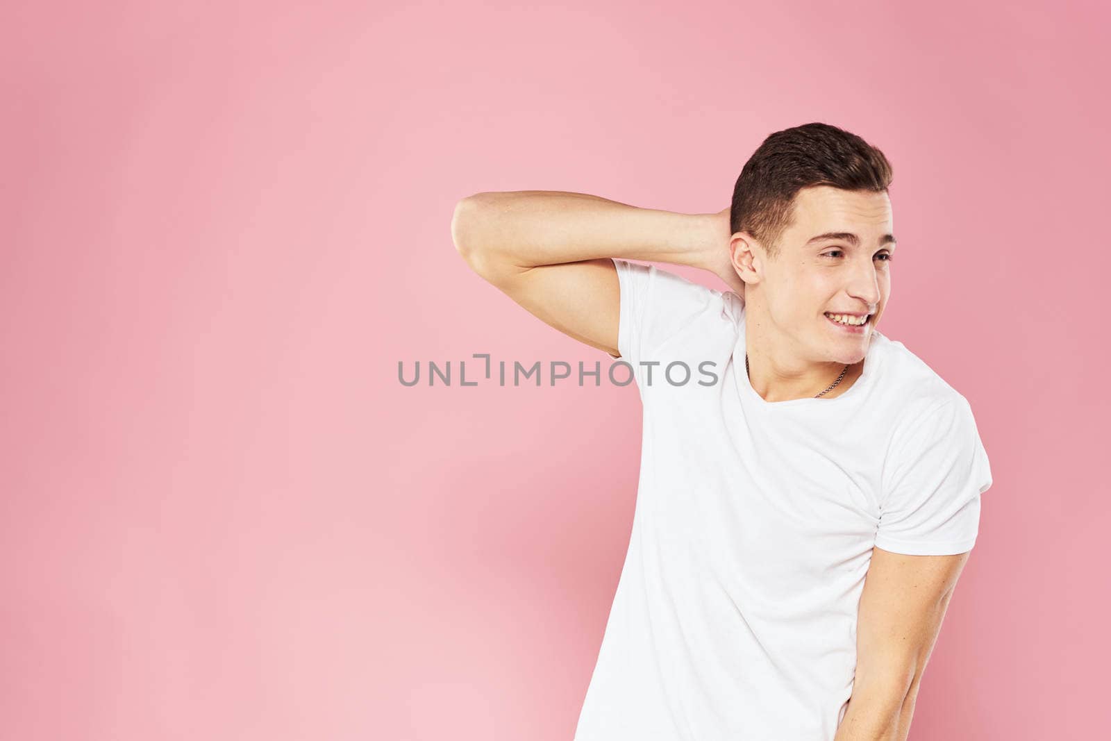 Emotional man gesturing with his hands white t-shirt pink isolated background by SHOTPRIME