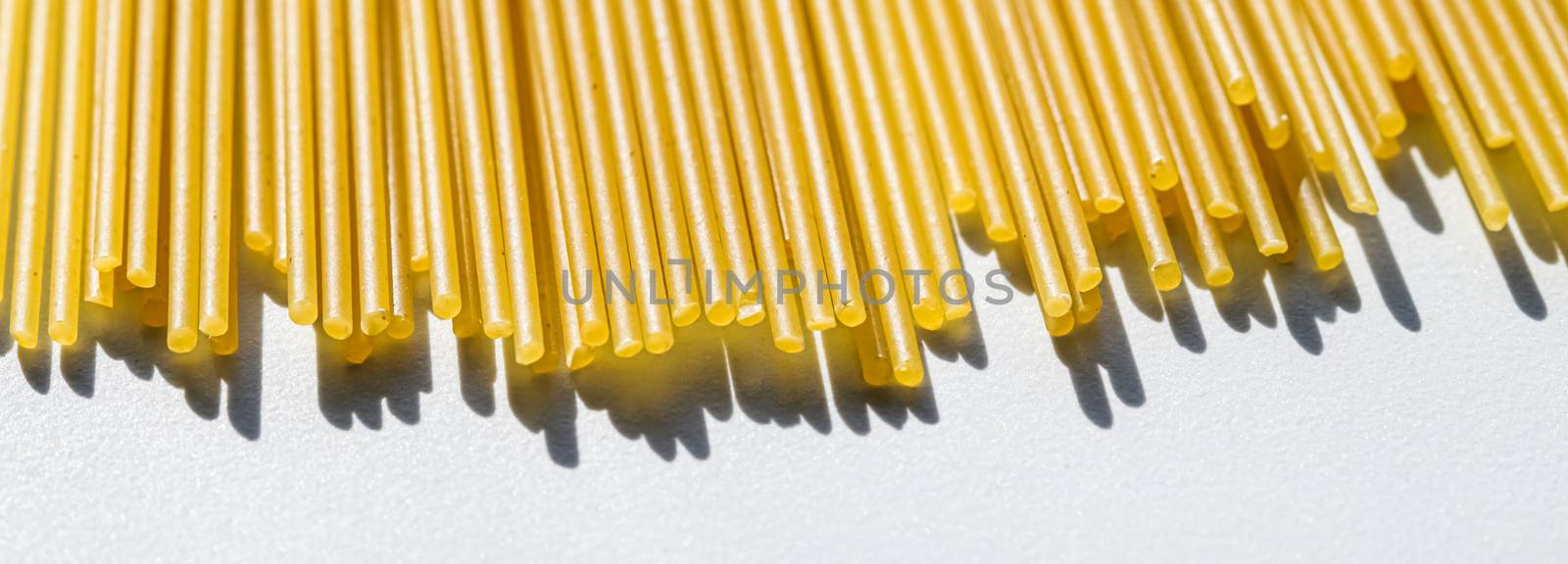 Uncooked whole grain spaghetti closeup, italian pasta as organic food ingredient, macro product and cook book recipes