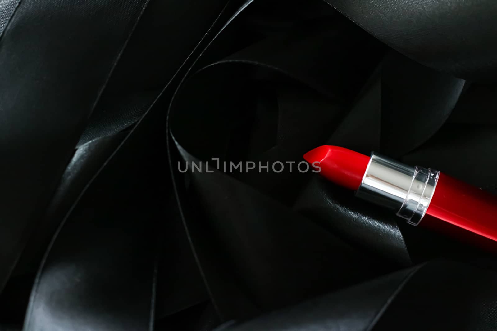 Red lipstick on black silk background, luxury make-up and beauty cosmetics