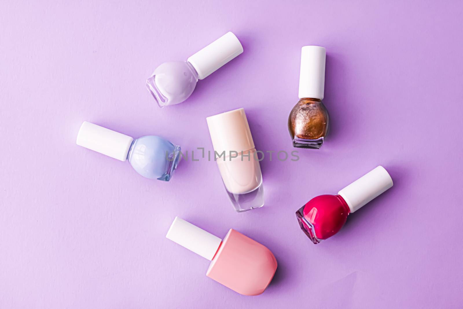 Nail polish bottles on purple background, beauty brand by Anneleven