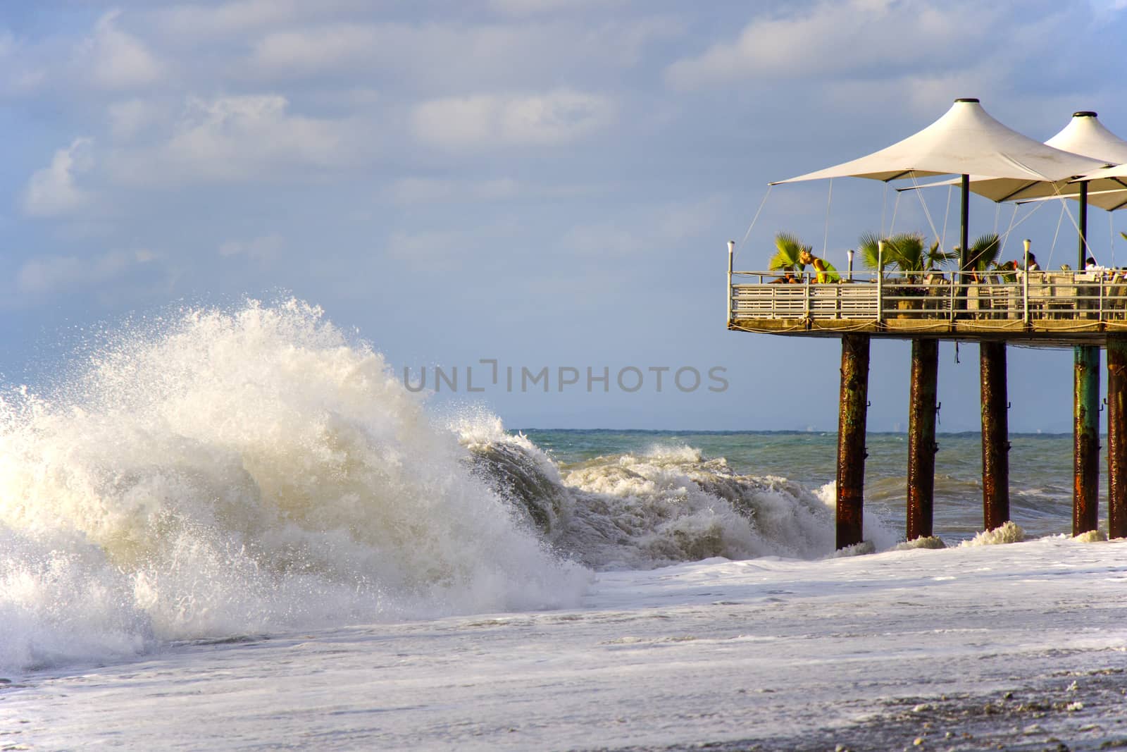 People in vacation. Stormy weather, waves and splashes in Batumi, Georgia. Stormy Black sea. by Taidundua