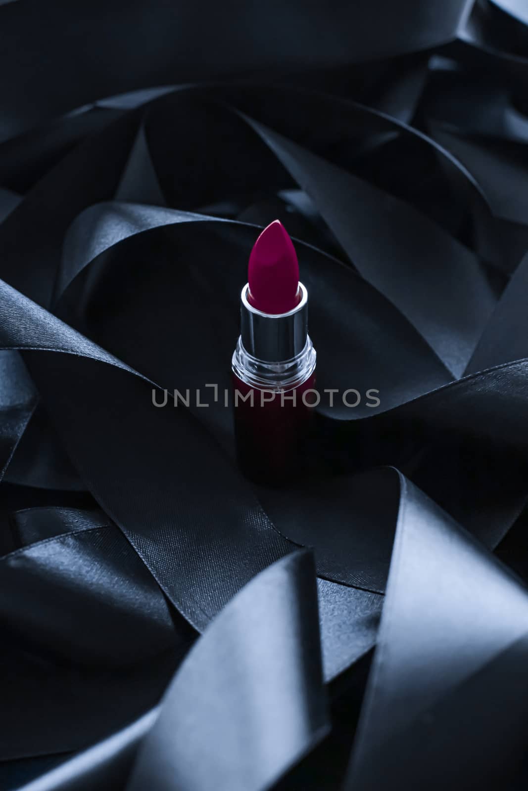 Purple lipstick on black silk background, luxury make-up and beauty cosmetics