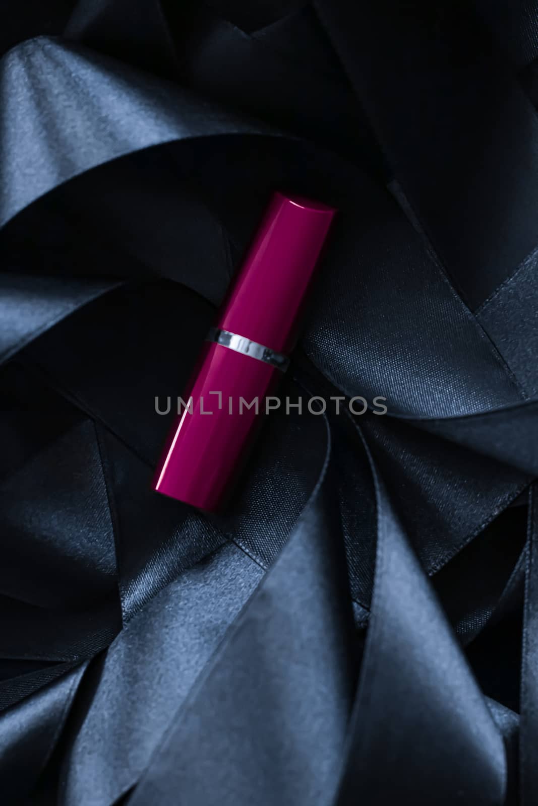 Purple lipstick on black silk background, luxury make-up and beauty cosmetics