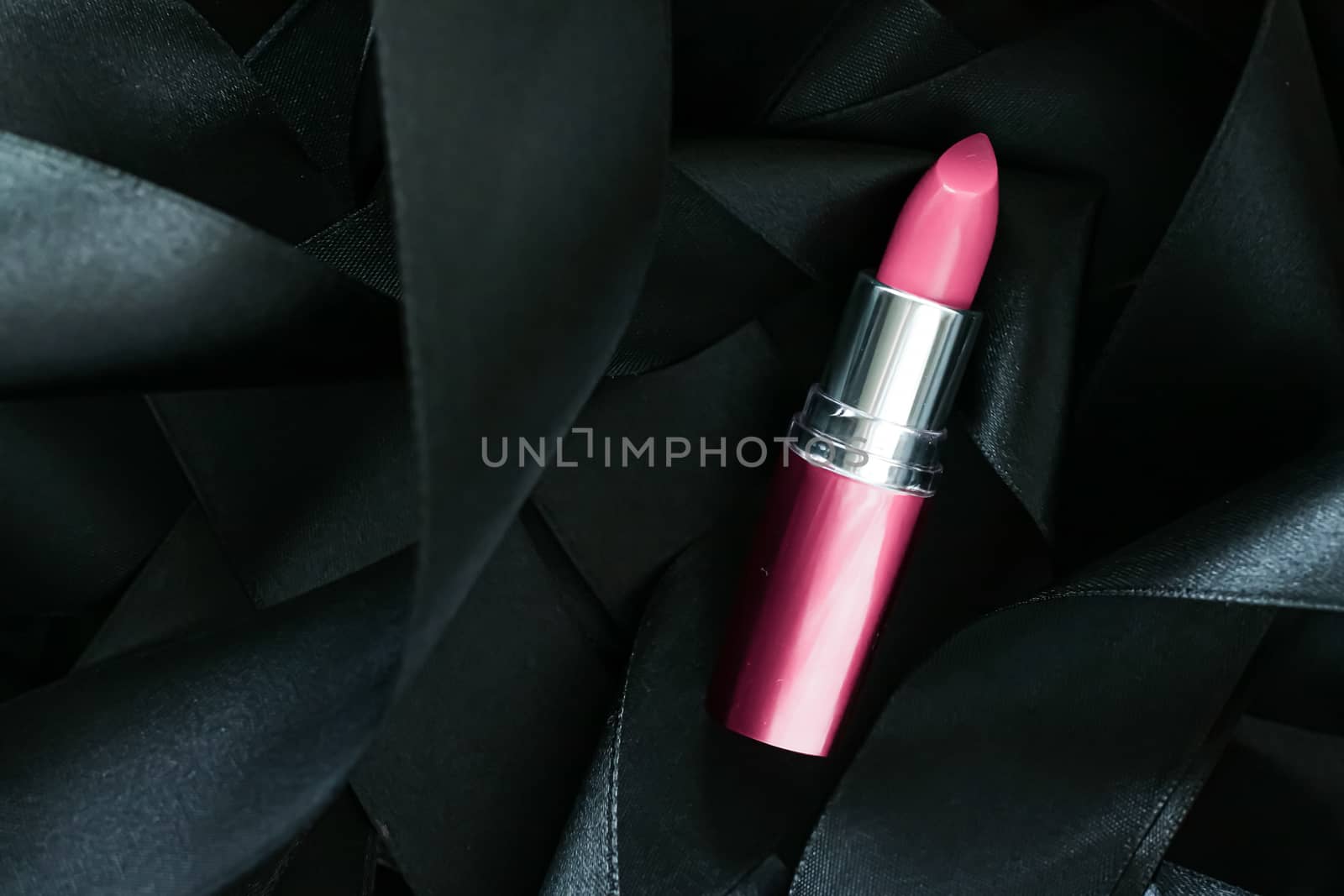 Pink lipstick on black silk background, luxury make-up and beauty cosmetics