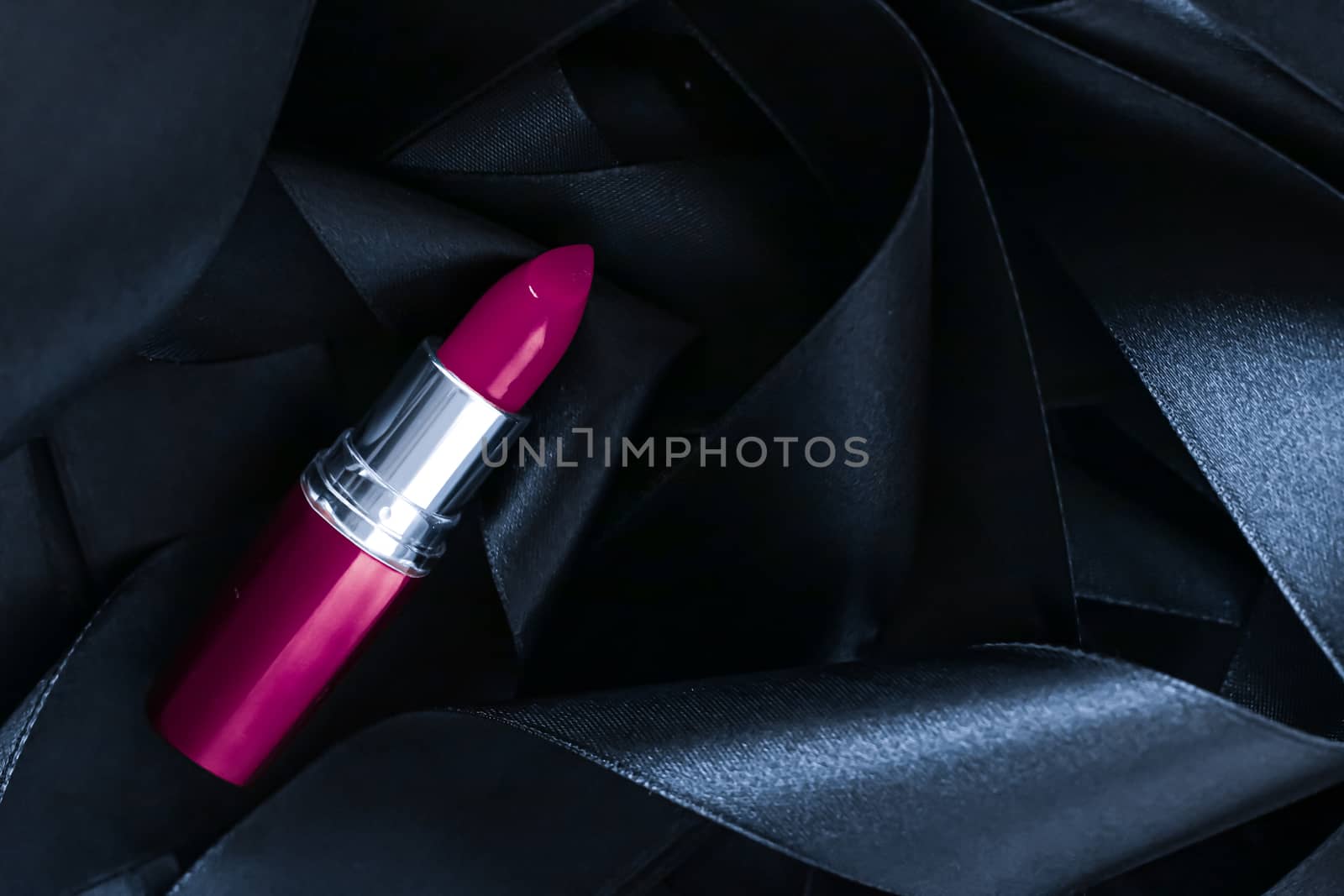 Purple lipstick on black silk background, luxury make-up and beauty cosmetics