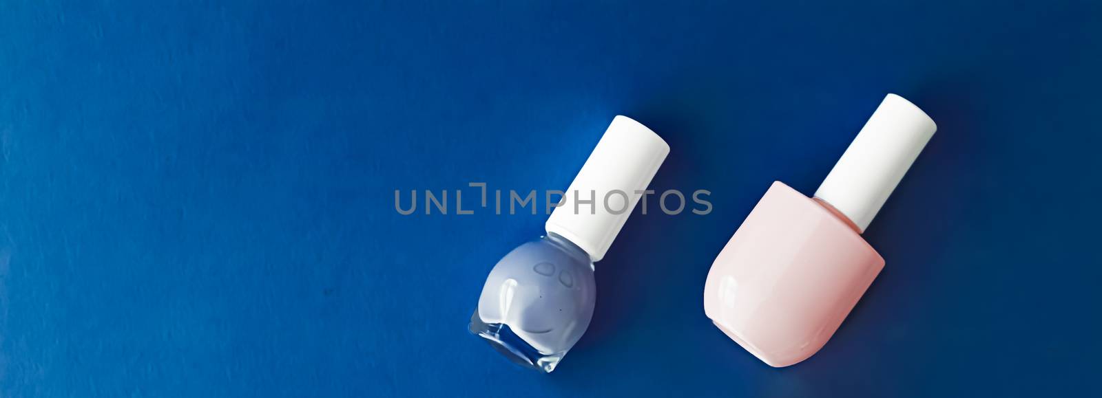 Nail polish bottles on dark blue background, beauty branding