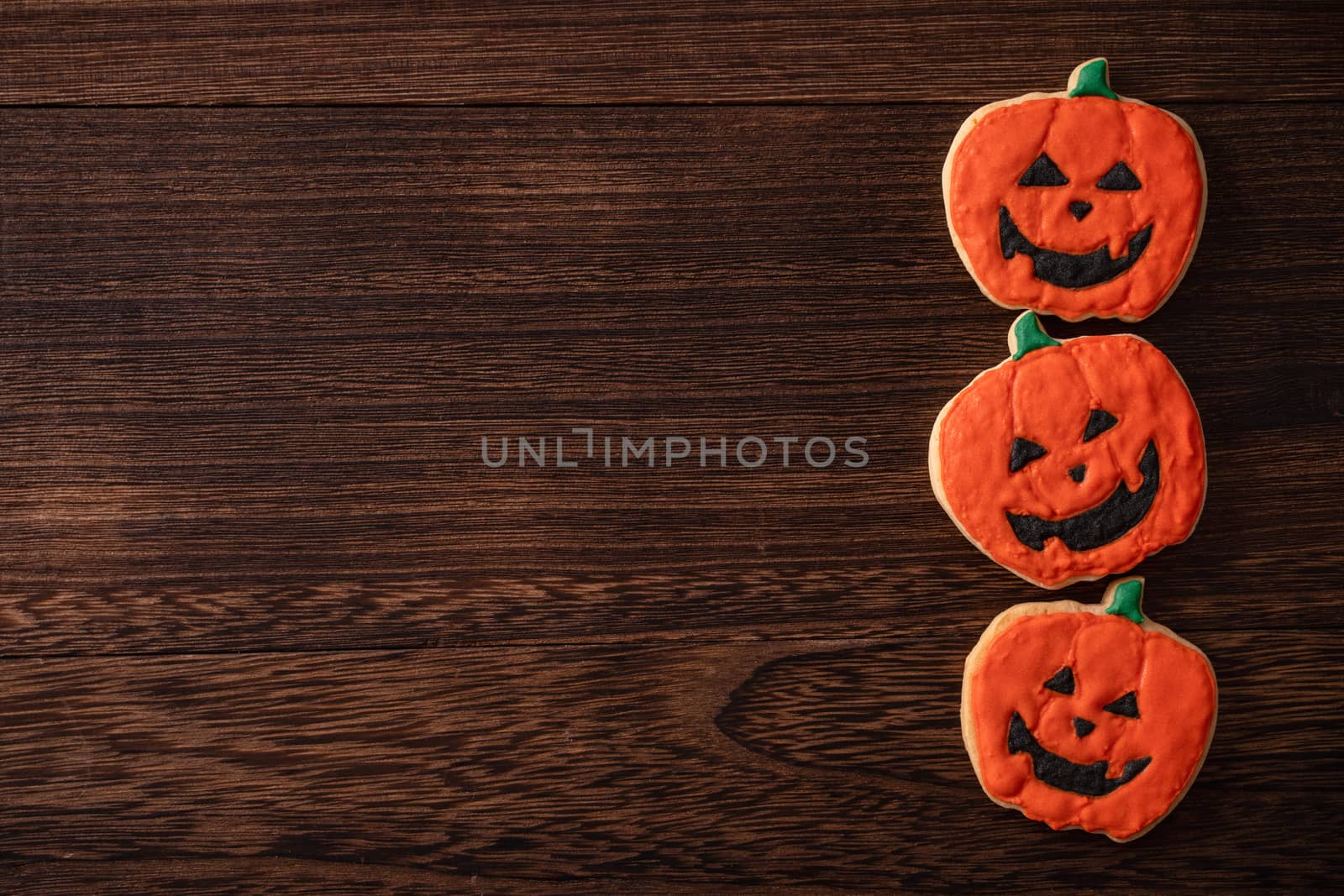 Top view of Halloween festive decorated icing gingerbread sugar cookies with copy space and flat lay layout.