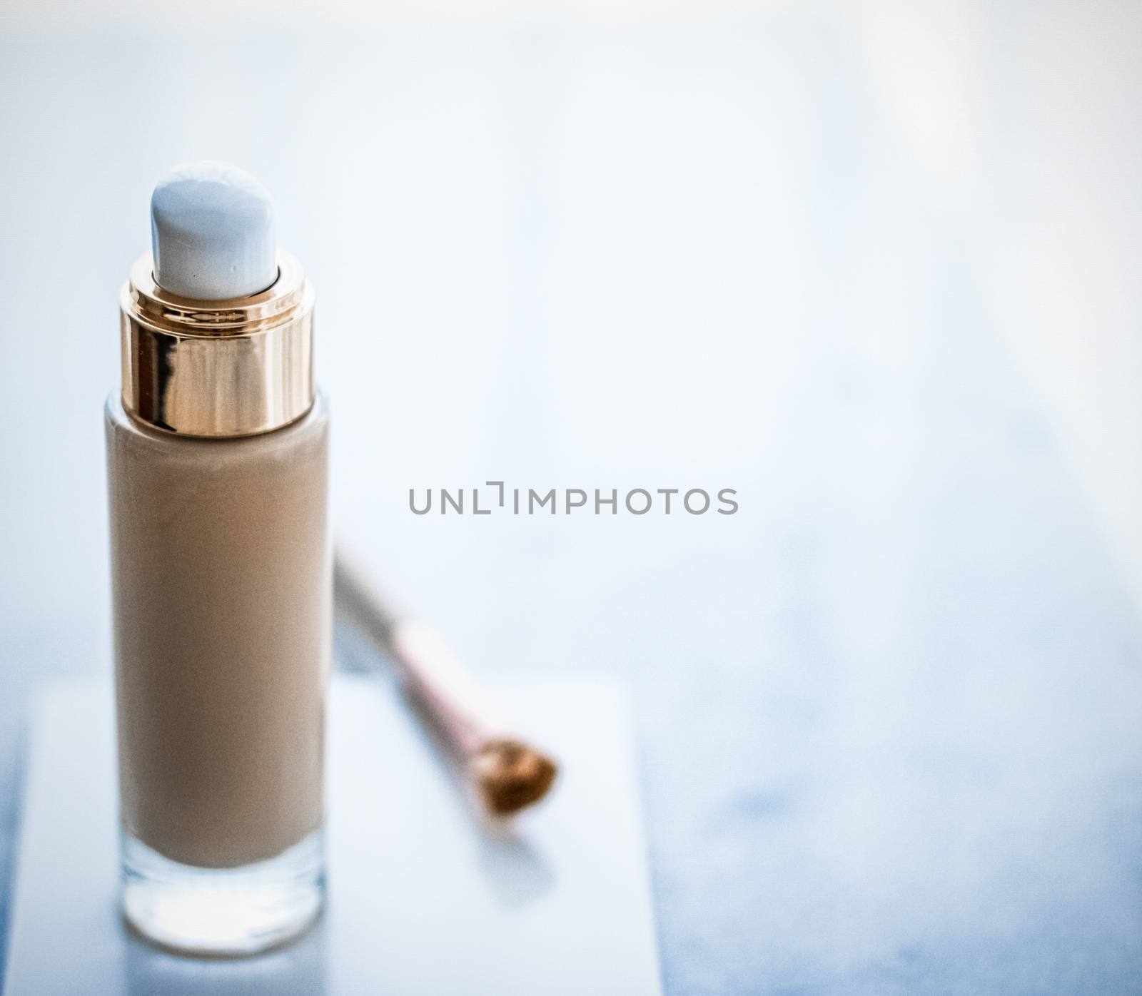 Makeup foundation bottle and contouring brush on marble, make-up by Anneleven