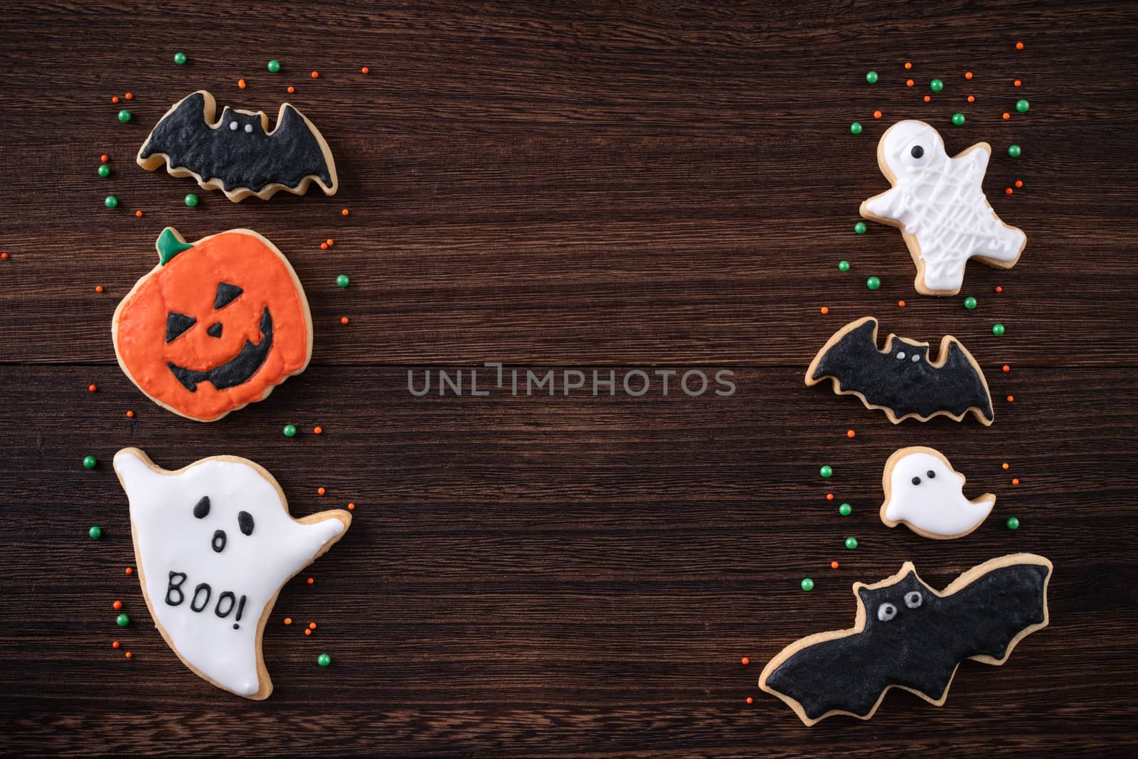 Top view of Halloween festive decorated icing gingerbread sugar cookies with copy space and flat lay layout.