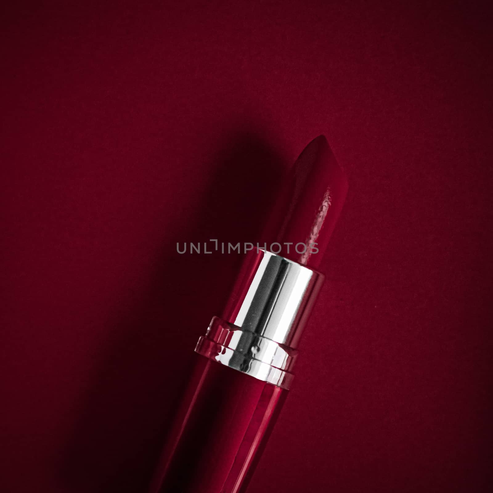 Luxury lipstick and silk ribbon on maroon holiday background, ma by Anneleven