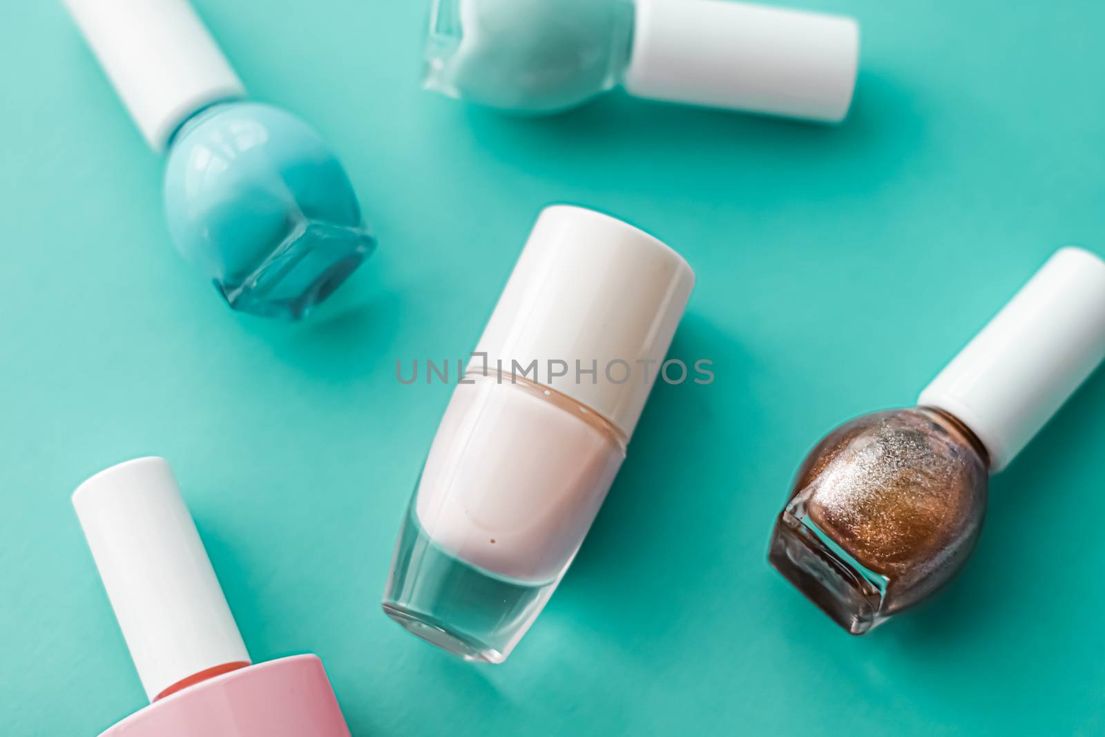 Nail polish bottles on green background, beauty branding