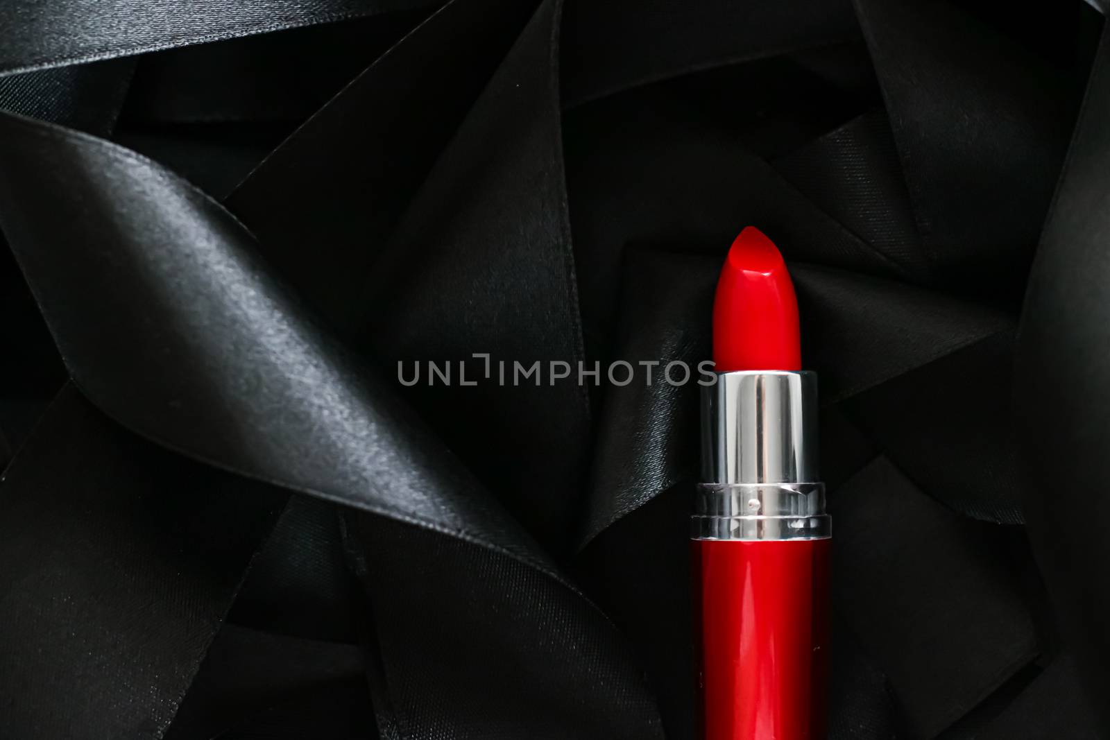 Red lipstick on black silk background, luxury make-up and beauty cosmetics