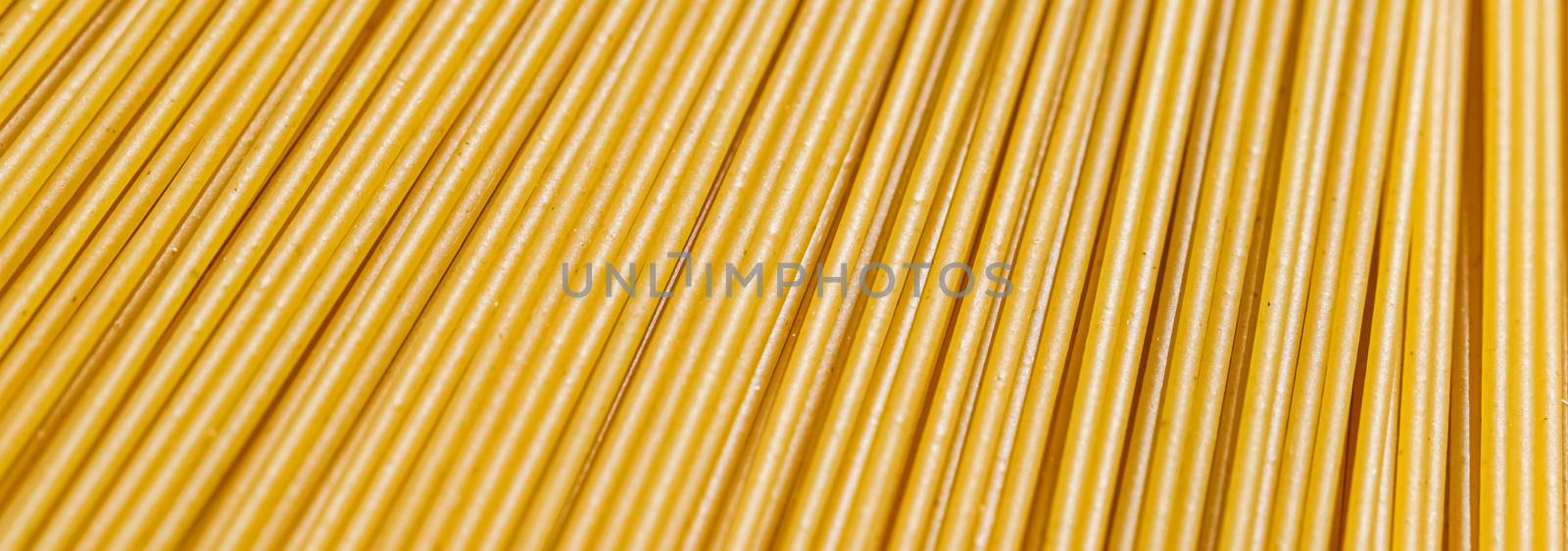 Uncooked whole grain spaghetti closeup, italian pasta as organic food ingredient, macro product and cook book recipes