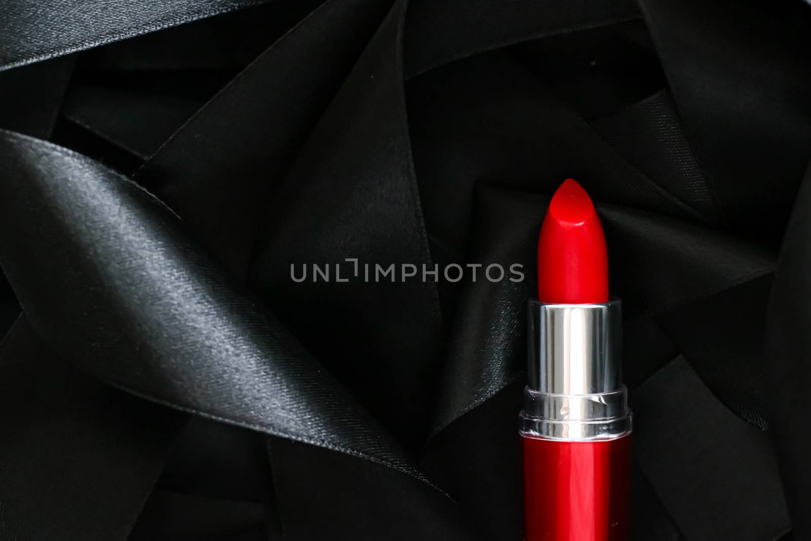 Red lipstick on black silk background, luxury make-up and beauty cosmetics