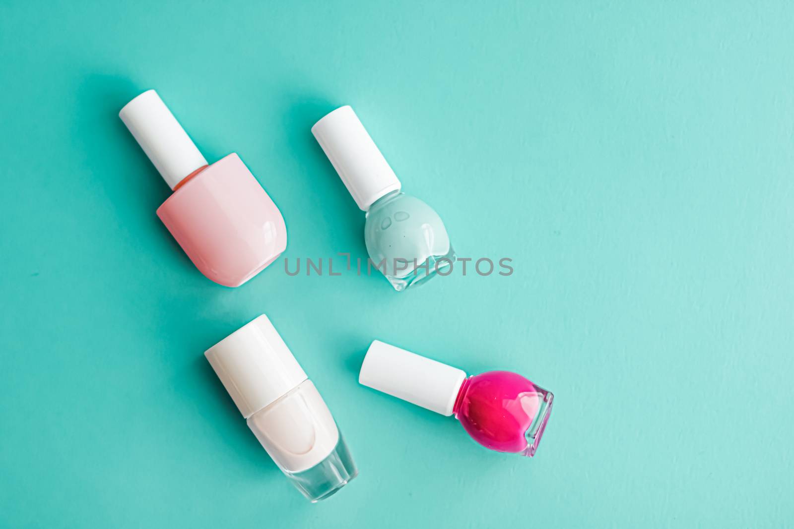 Nail polish bottles on green background, beauty branding