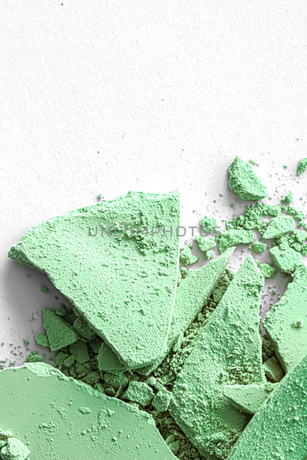 Green eye shadow powder as makeup palette closeup isolated on white background, crushed cosmetics and beauty textures