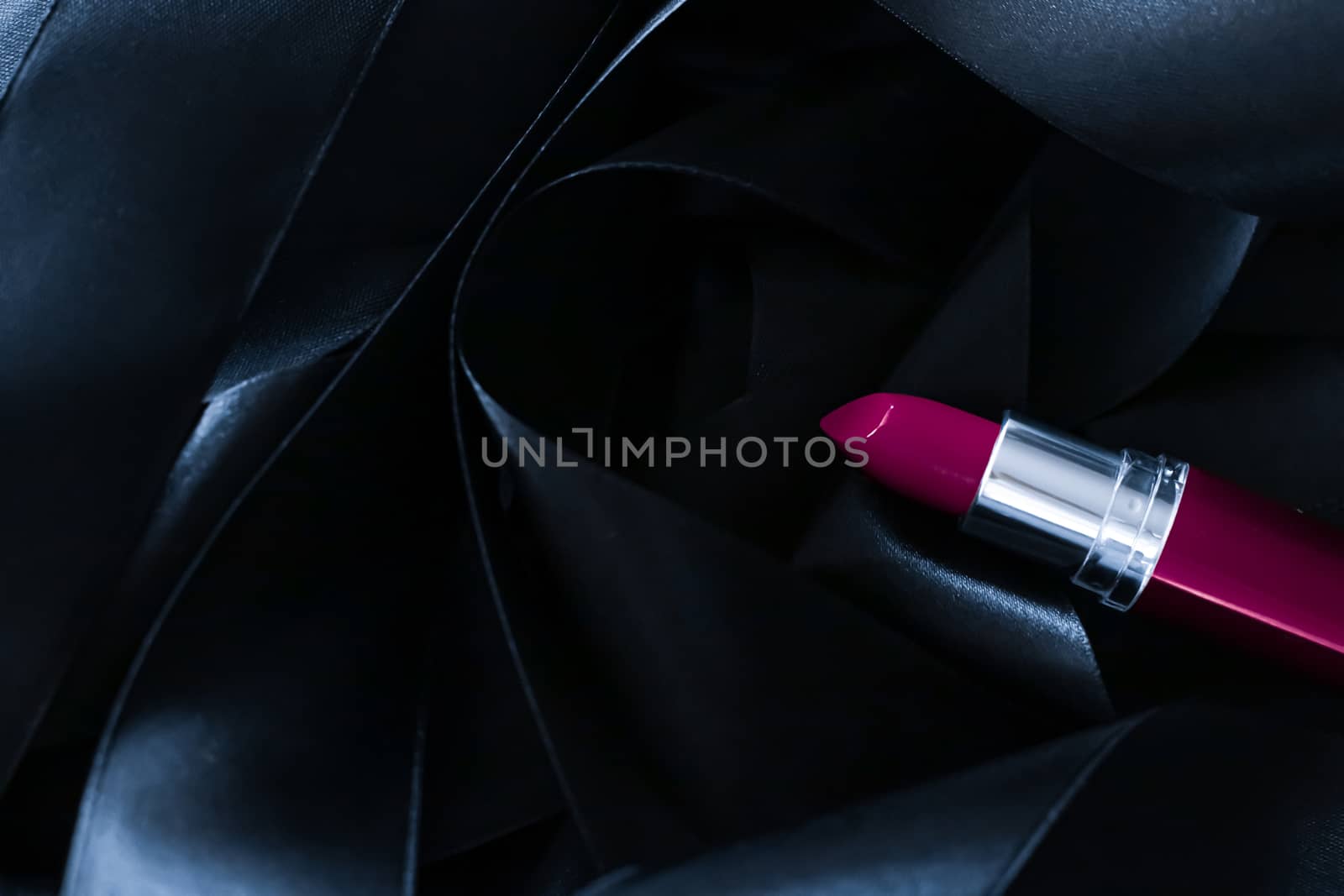 Purple lipstick on black silk background, luxury make-up and beauty cosmetics